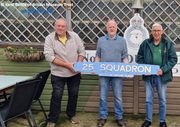 Three men holding the exact copy of the 25 Squadron locomotive nameplate outside the Museum’s No. 25 Squadron tearoom