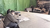 Museum volunteers removing old paint from port and starboard wings.