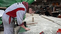 Museum volunteer Ant replacing damaged wing panel.