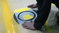 Upper wing stencil being lined up in preparation for spraying.