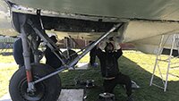 Museum volunteers preparing the fuselage underside for painting.
