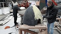 Ben Lavender preparing one of the spinners for re-painting whilst Brad Day works on one of the engine cowlings.