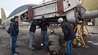 With James Gilmour, ARCO's Hangar / Maintenance Manager, Billy from ARCo showing the Museum Volunteers how to lower and lock the undercarriage legs back into place and reattach the main undercarriage wheels.