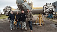 Museum volunteers Dave Brocklehurst MBE, David Hertz, Clint Michell and Rick Kent by the Heinkel fuselage at ARCO, at IWM Duxford.