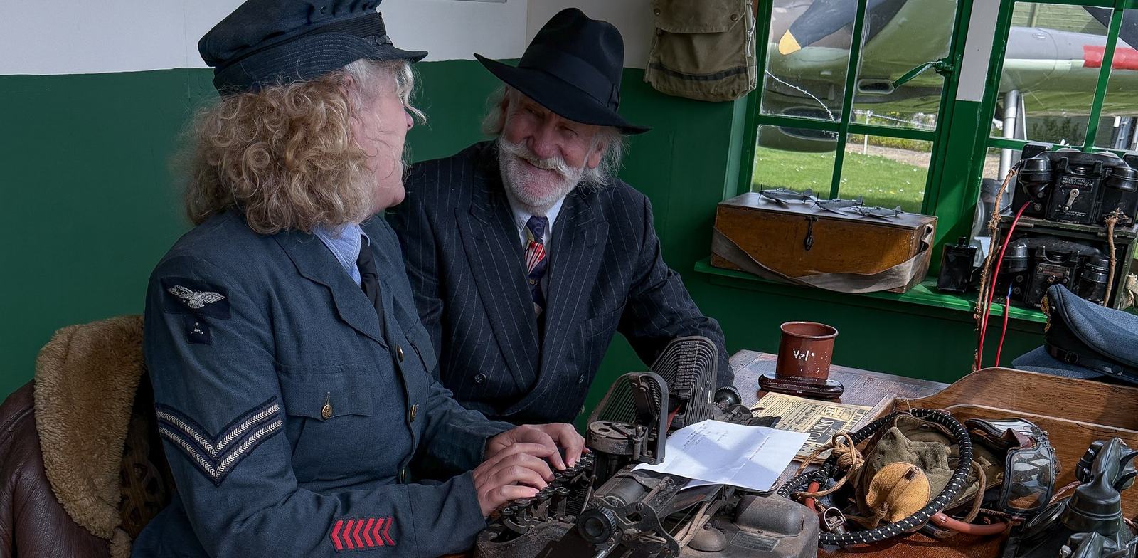 Museum volunteers in wartime dress at a typewriter in the reconstructed Watch Office